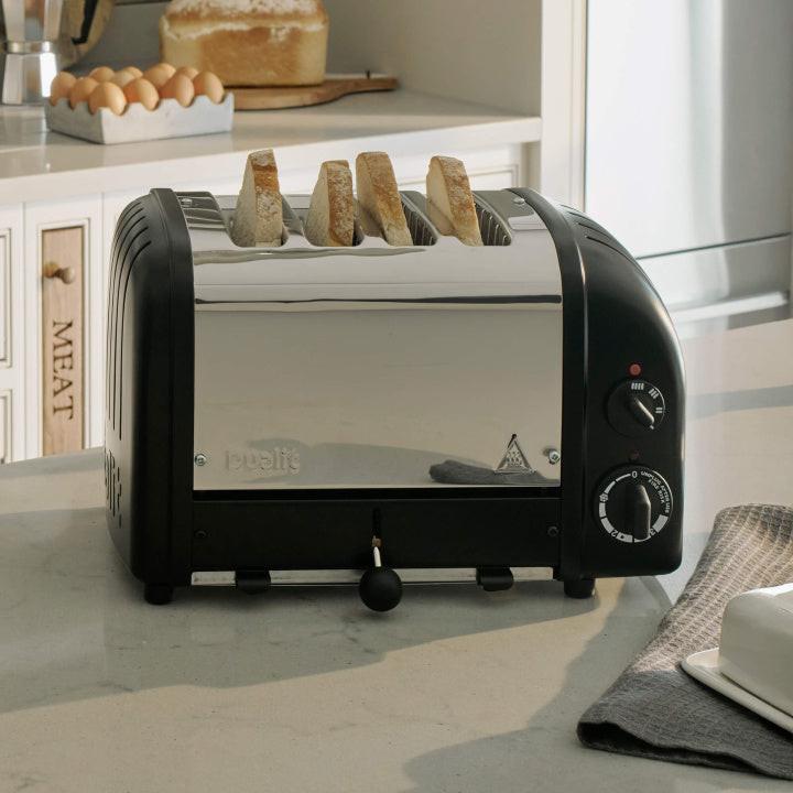 Matte black 4-slice toaster with crumb tray and control knobs, bread slot