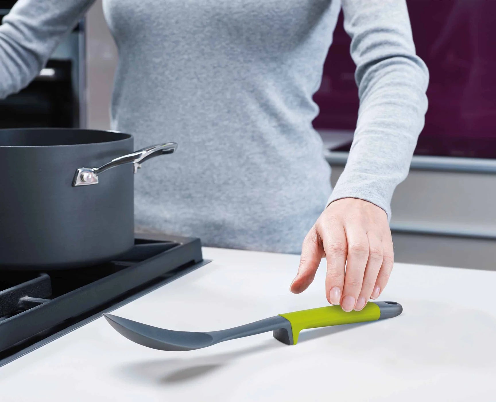 Grey silicone spatula with green handle from utensil set