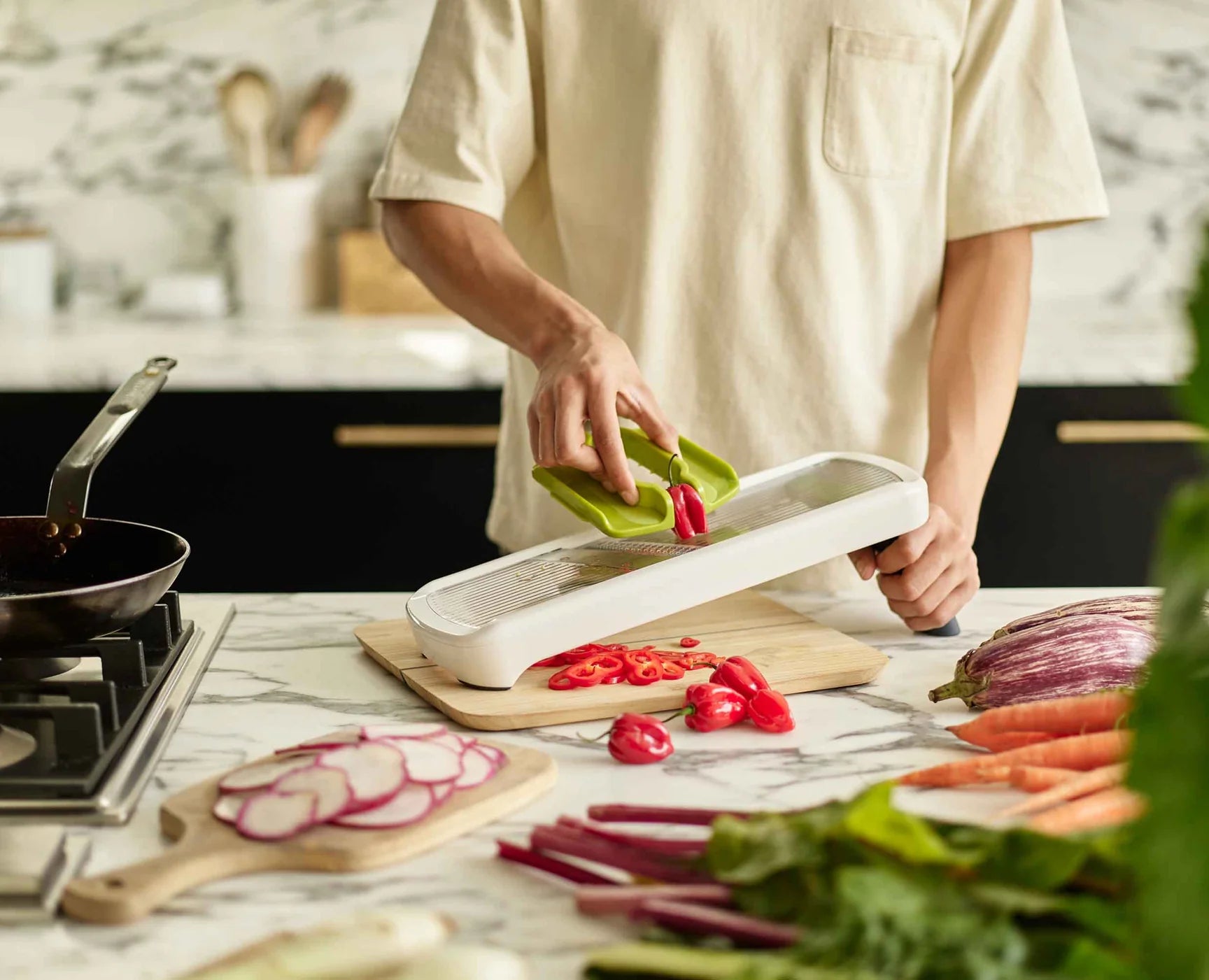 White adjustable kitchen mandoline slicer with sliding food holder and hand grip