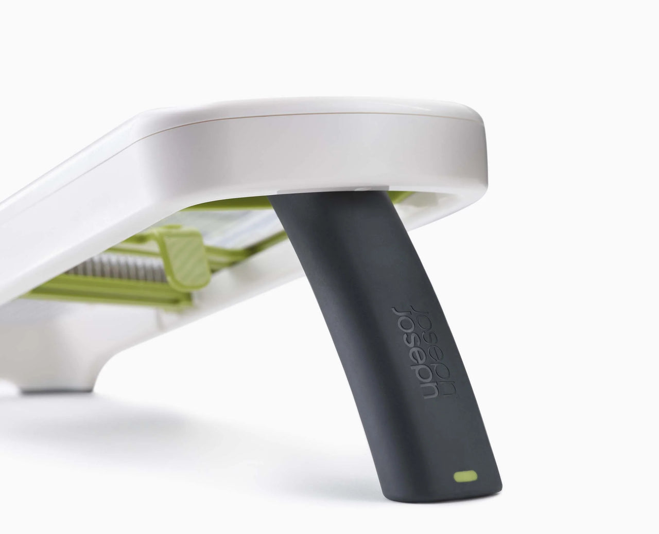 White mandoline top with black push handle attached and green insert