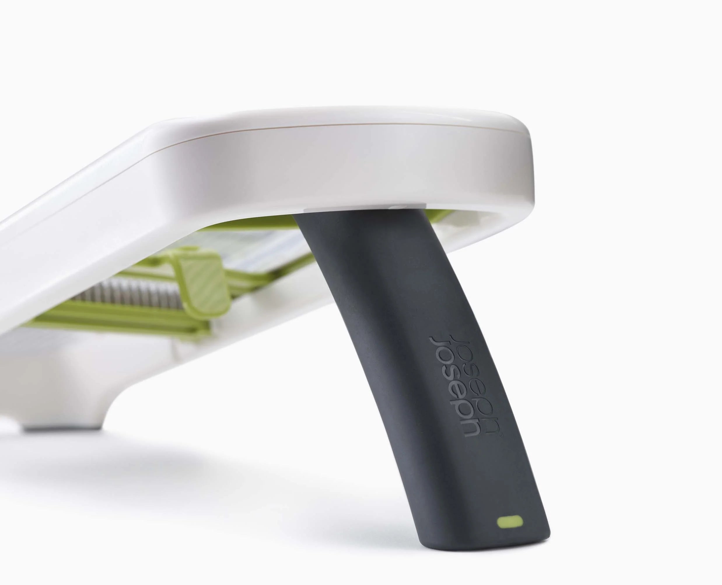 White mandoline top with black push handle attached and green insert