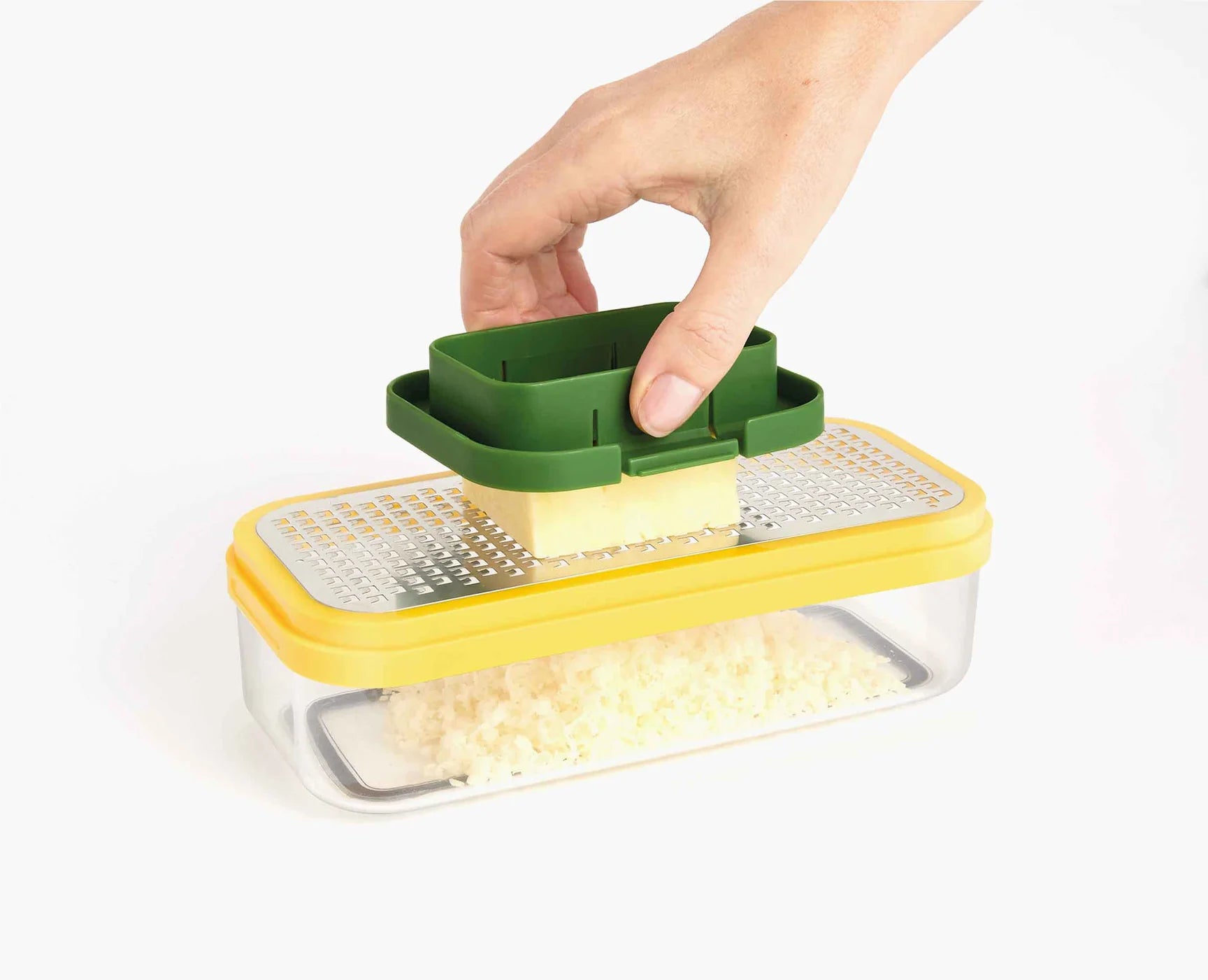 Compact food prep chopper set with green handle on yellow base over grated ingredient tray