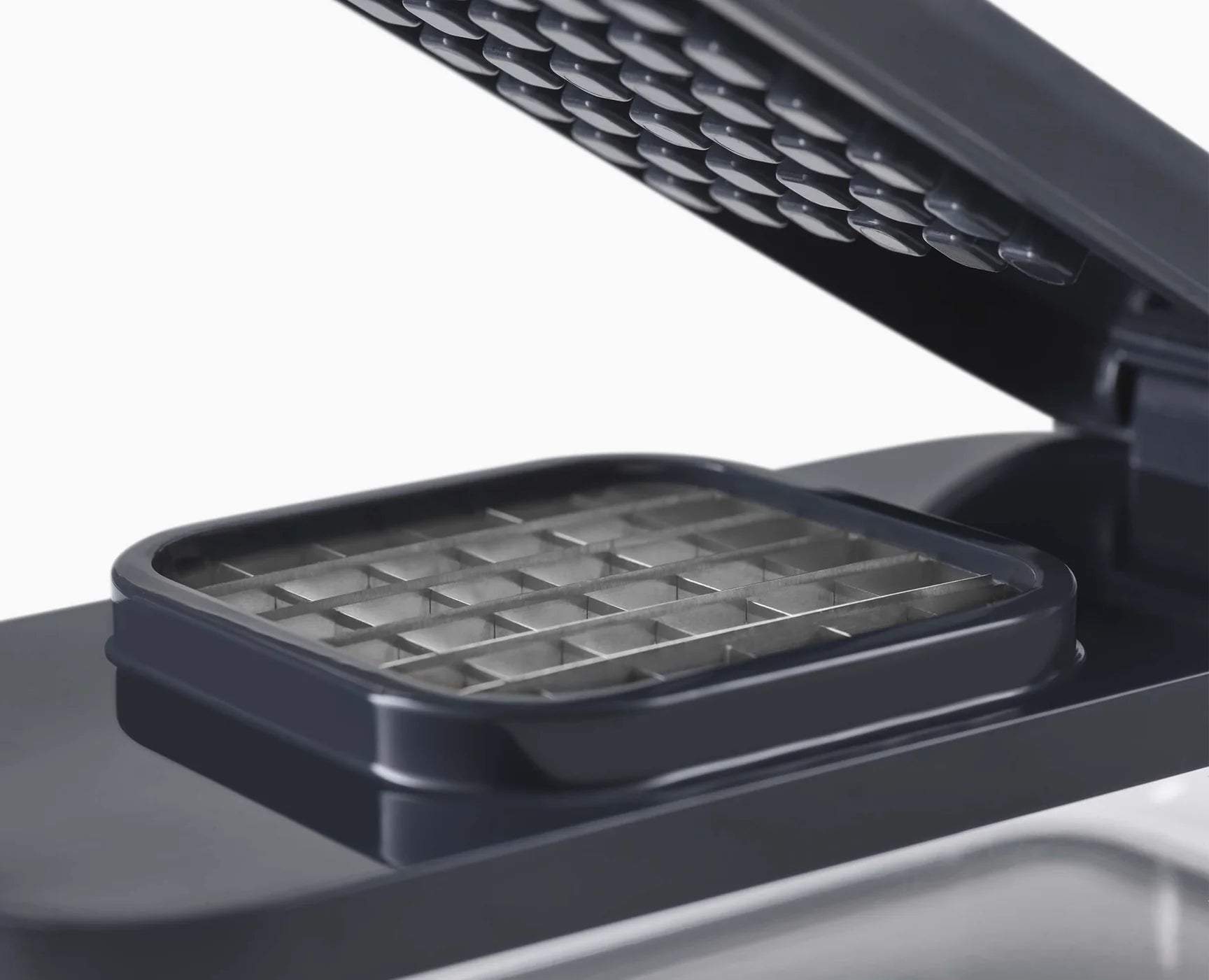 Compact food prep chopper set open with metal grater grid in dark base