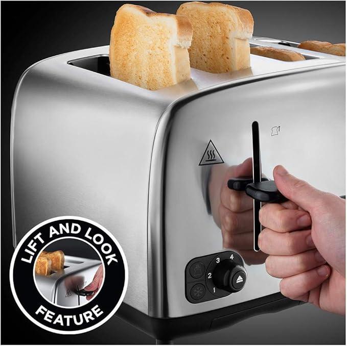 Silver toaster with open slots holding bread, side control dials and lever