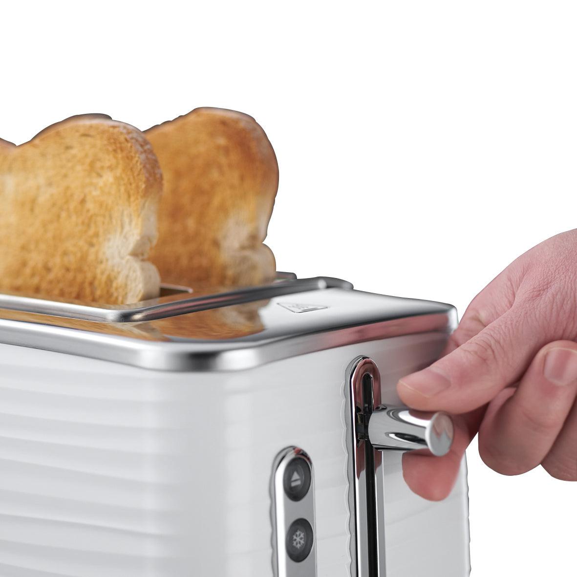 White 2-slice toaster with toast being inserted by hand