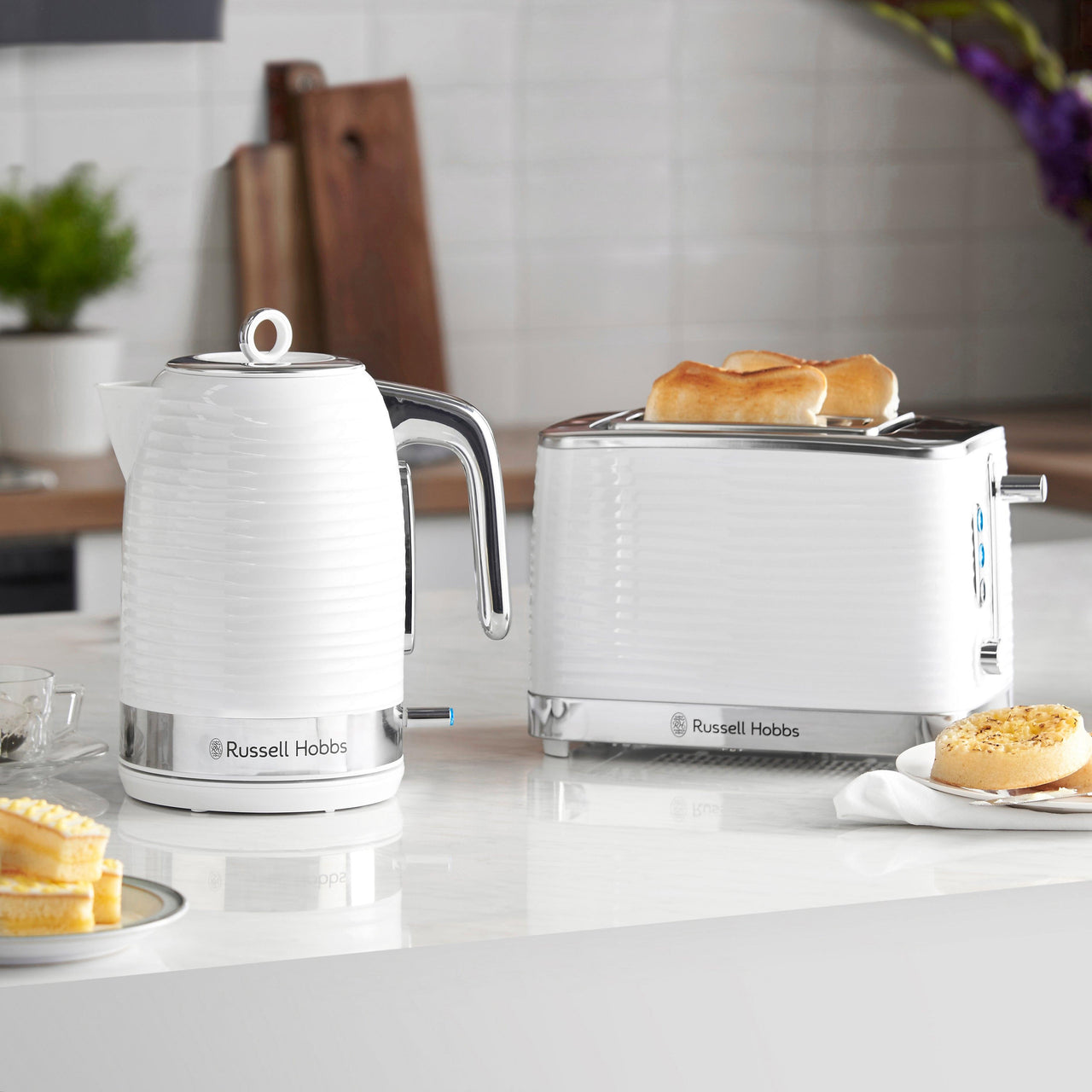 White 2-slice toaster with bread slots open and toasted slice on plate