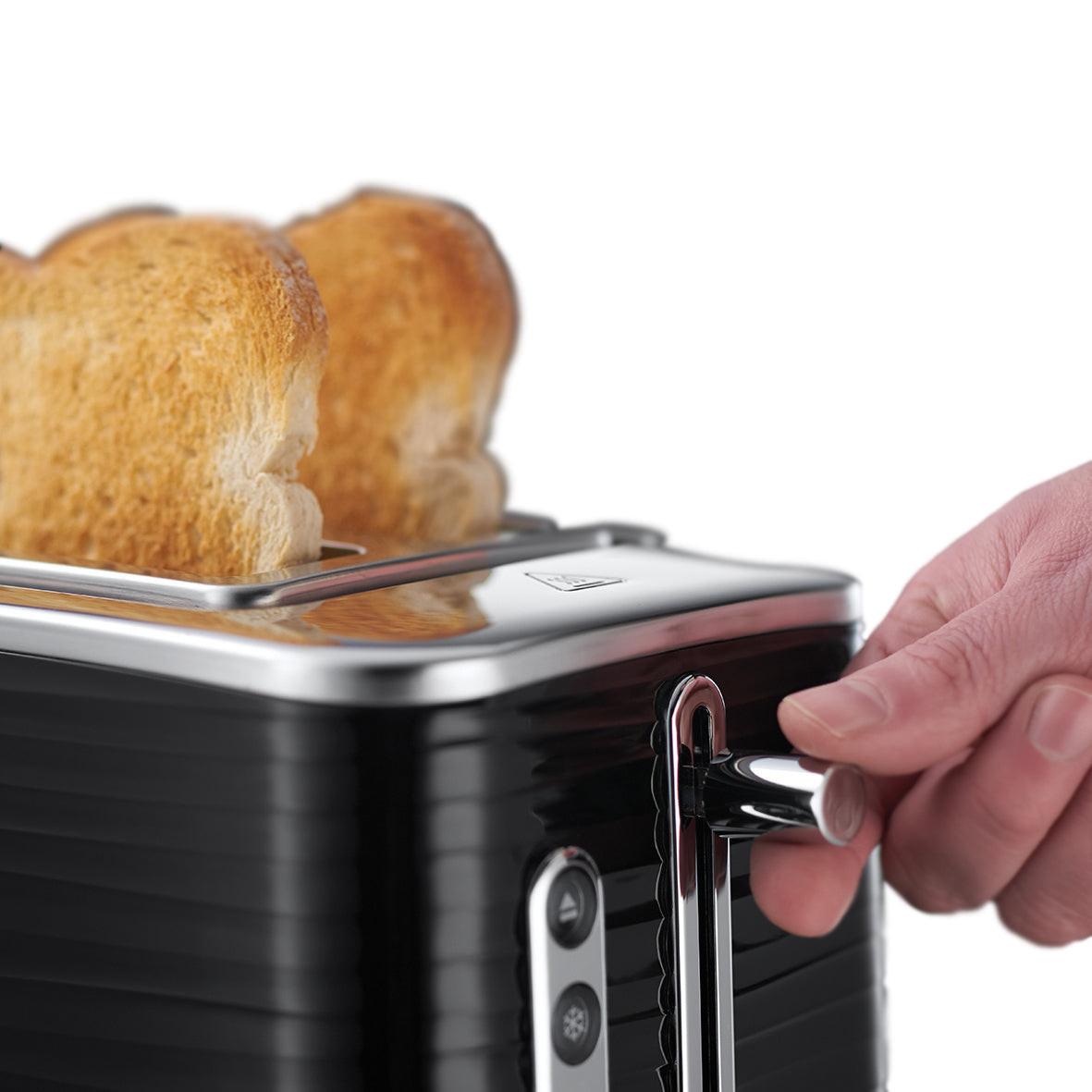 Black toaster with toasted bread in slots and hand holding the lift lever