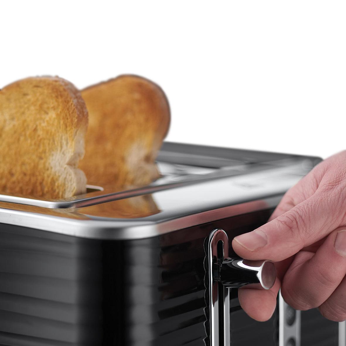 Black 4-slice toaster with open lever; hand pulling toast-lift handle