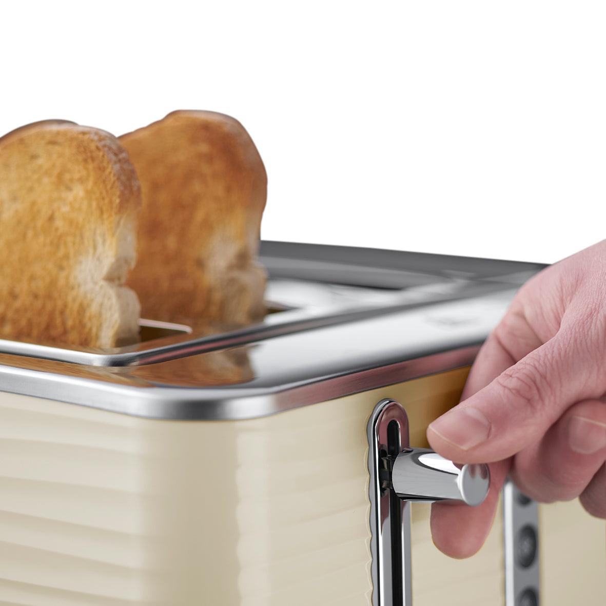 Cream 4-slice toaster with lever being lifted to raise bread