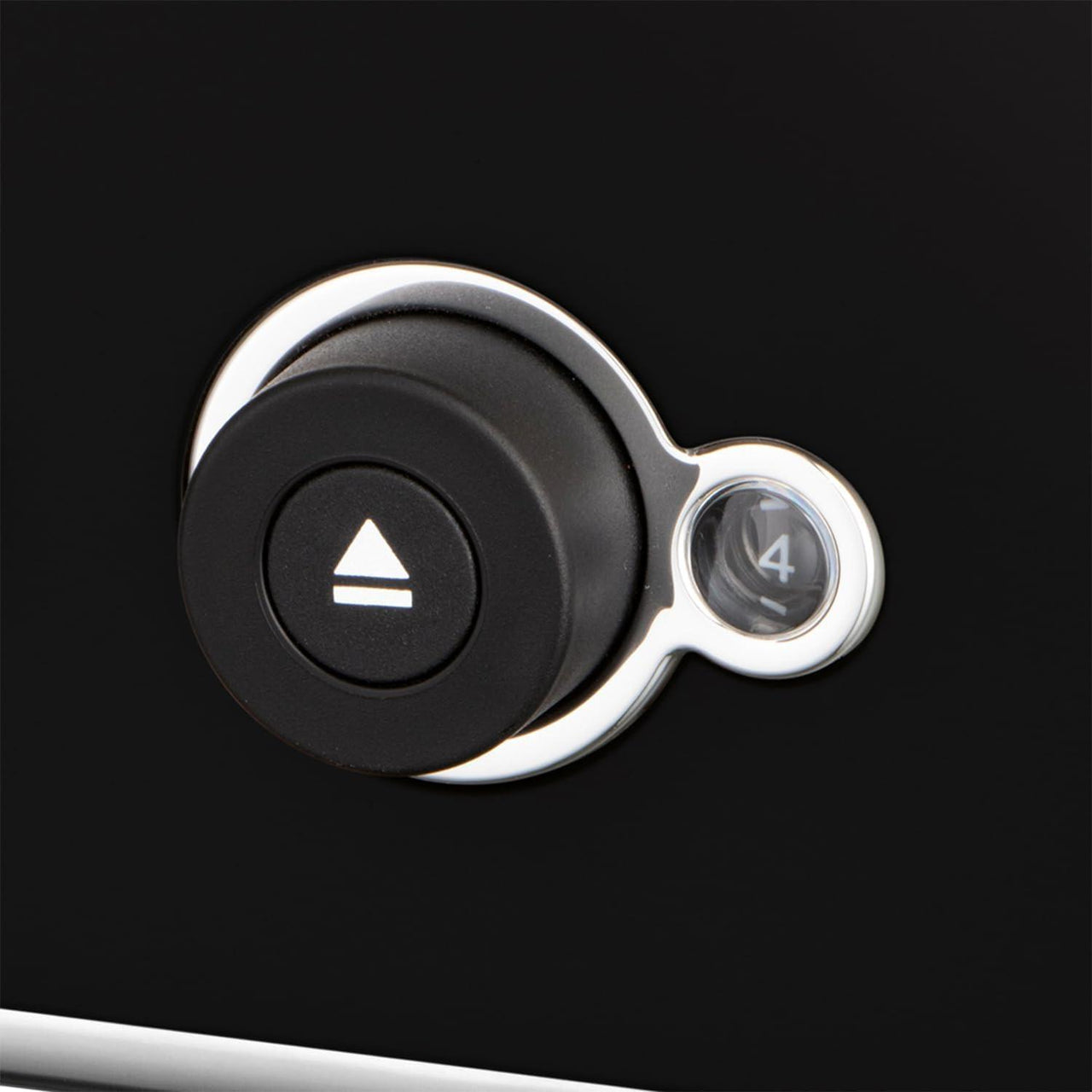 Close-up of black toaster power button and illuminated browning dial