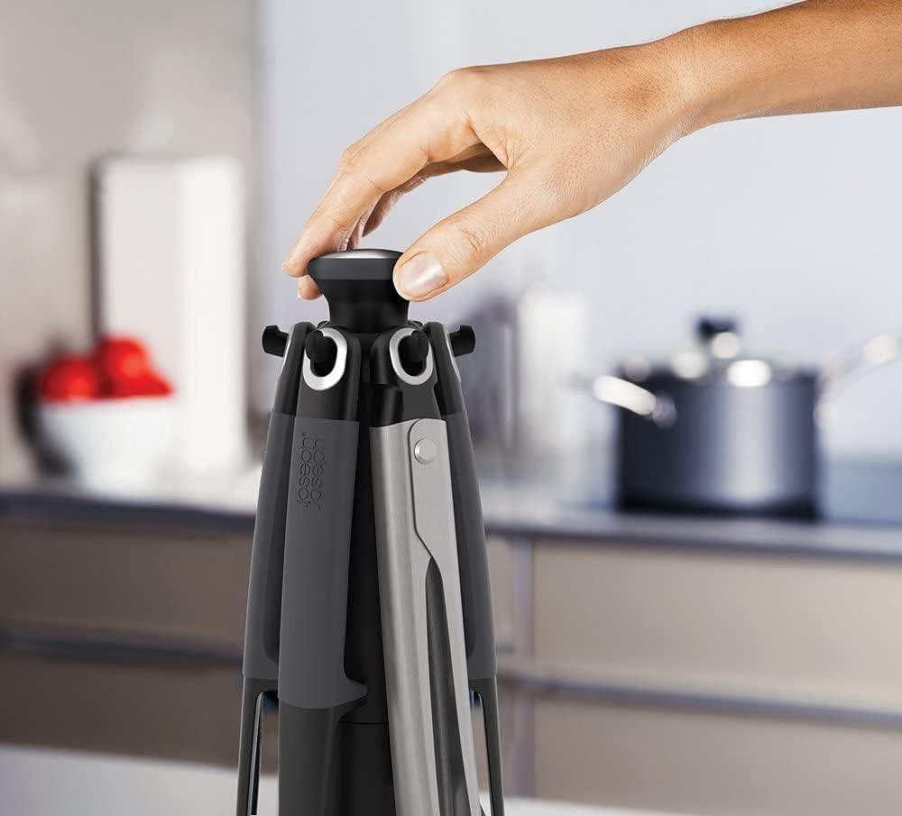 Hand placing a utensil into a gray carousel stand organizer