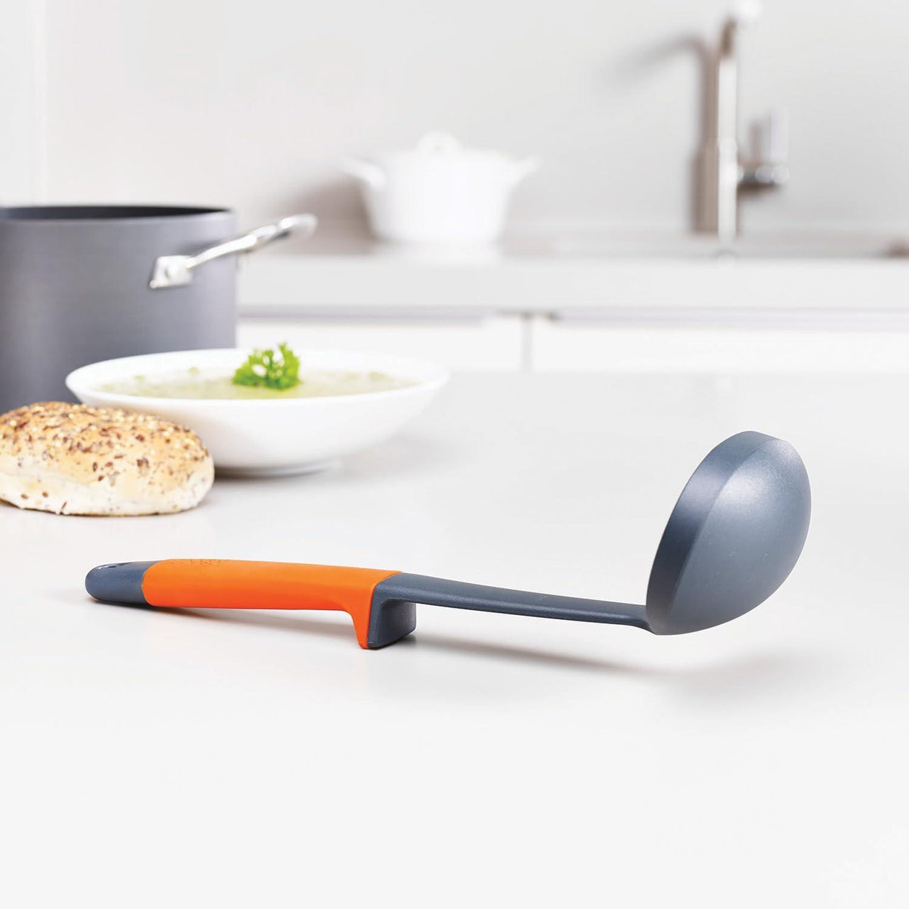 Kitchen ladle with orange handle and dark gray silicone bowl head, utensil set piece