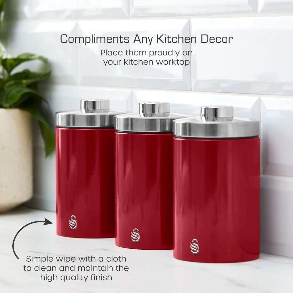 Three red kitchen canisters with chrome lids on countertop