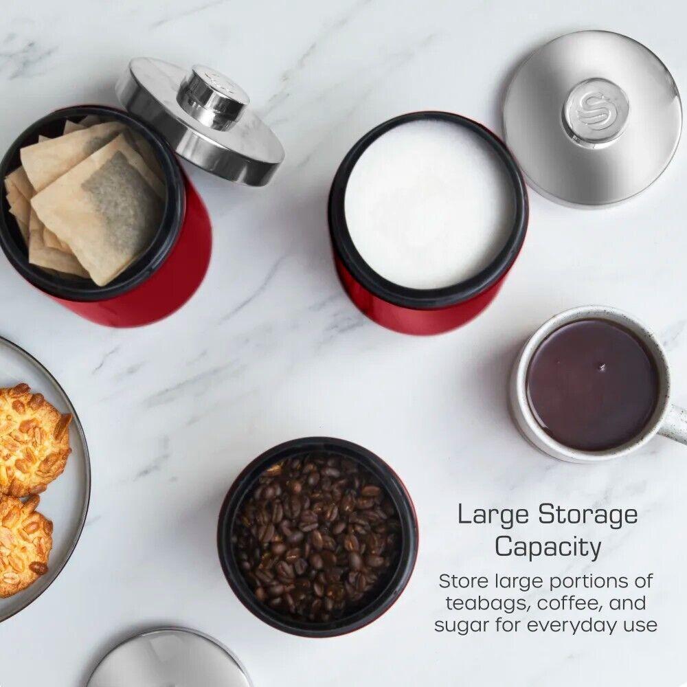 Red canisters with chrome lids, one open with coffee beans inside