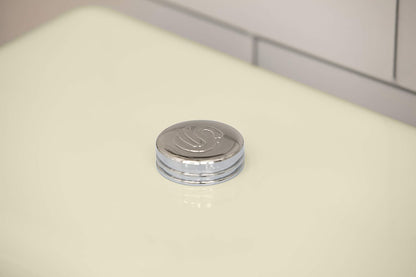 Cream retro bread bin lid cap with chrome knob and raised emblem, close-up.