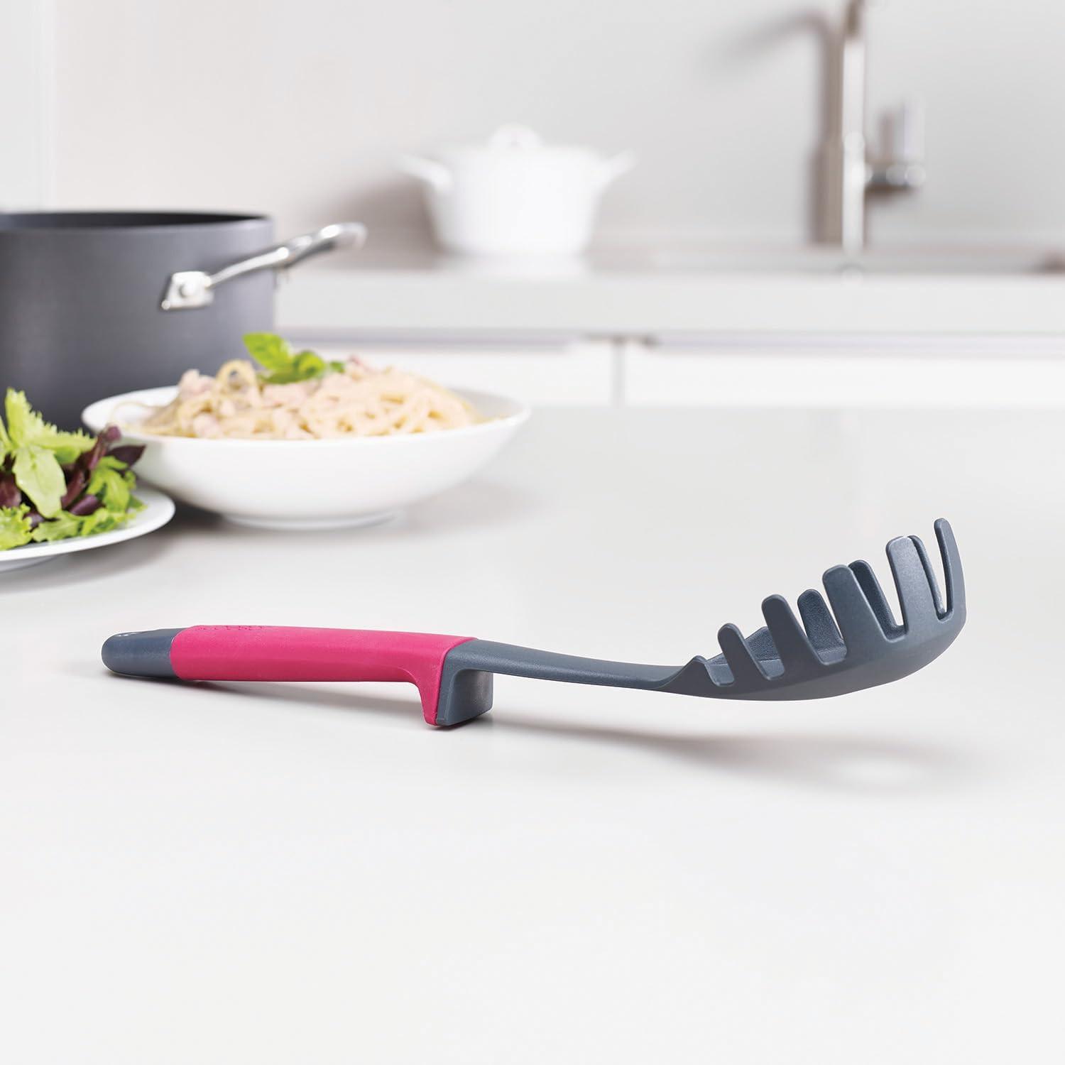 Kitchen slotted spatula with pink handle and dark gray ridged edge, utensil set piece