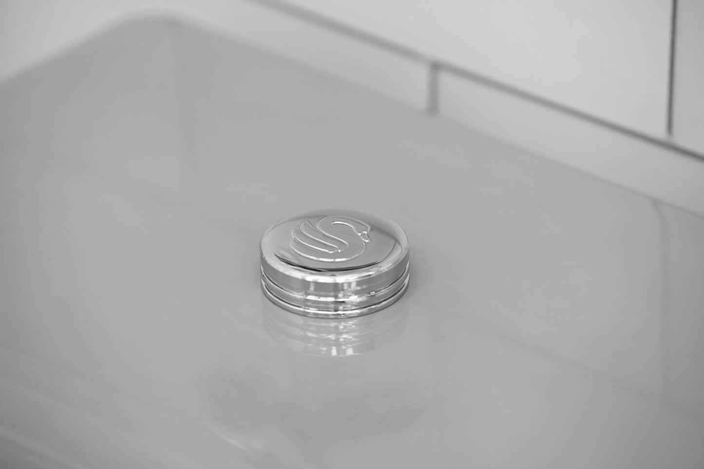 Top view of grey canister lid with silver ribbed trim and embossed knob