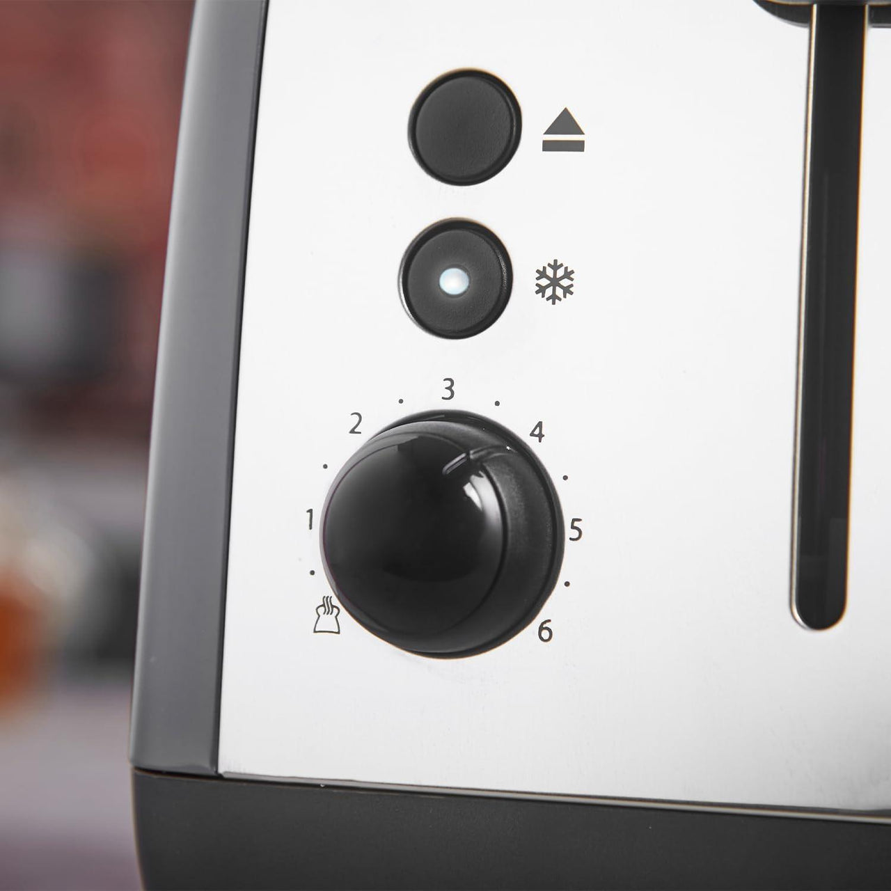 Grey toaster control dial with numbered browning scale and frost icon
