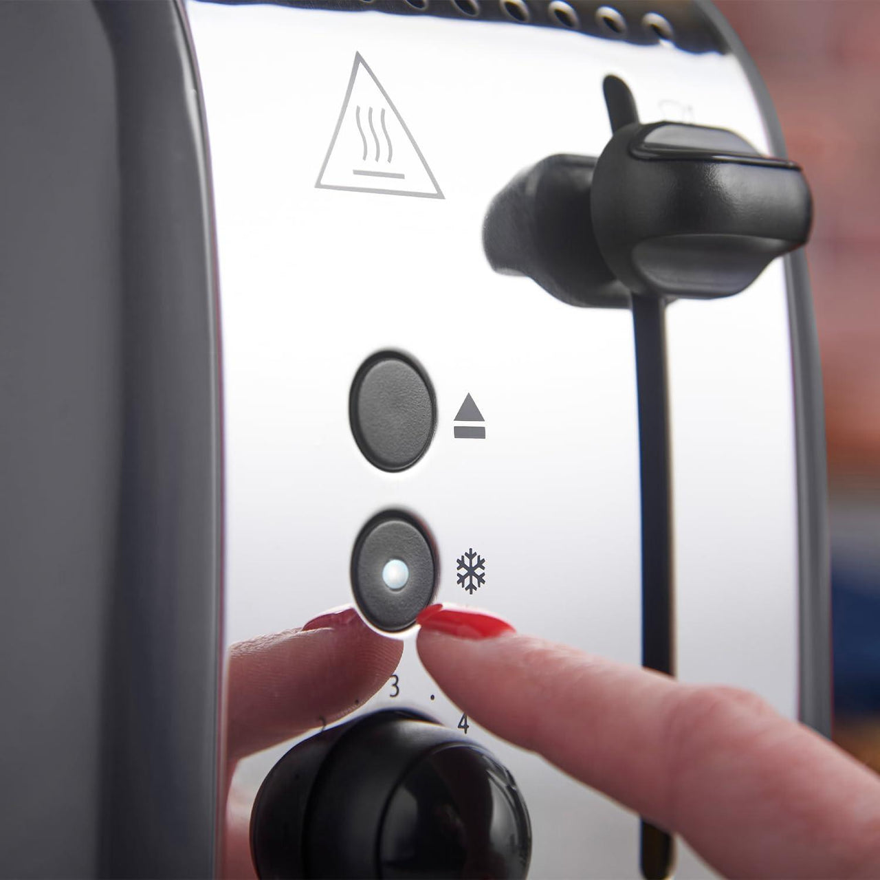 Grey toaster front controls with temperature dial and indicator icons