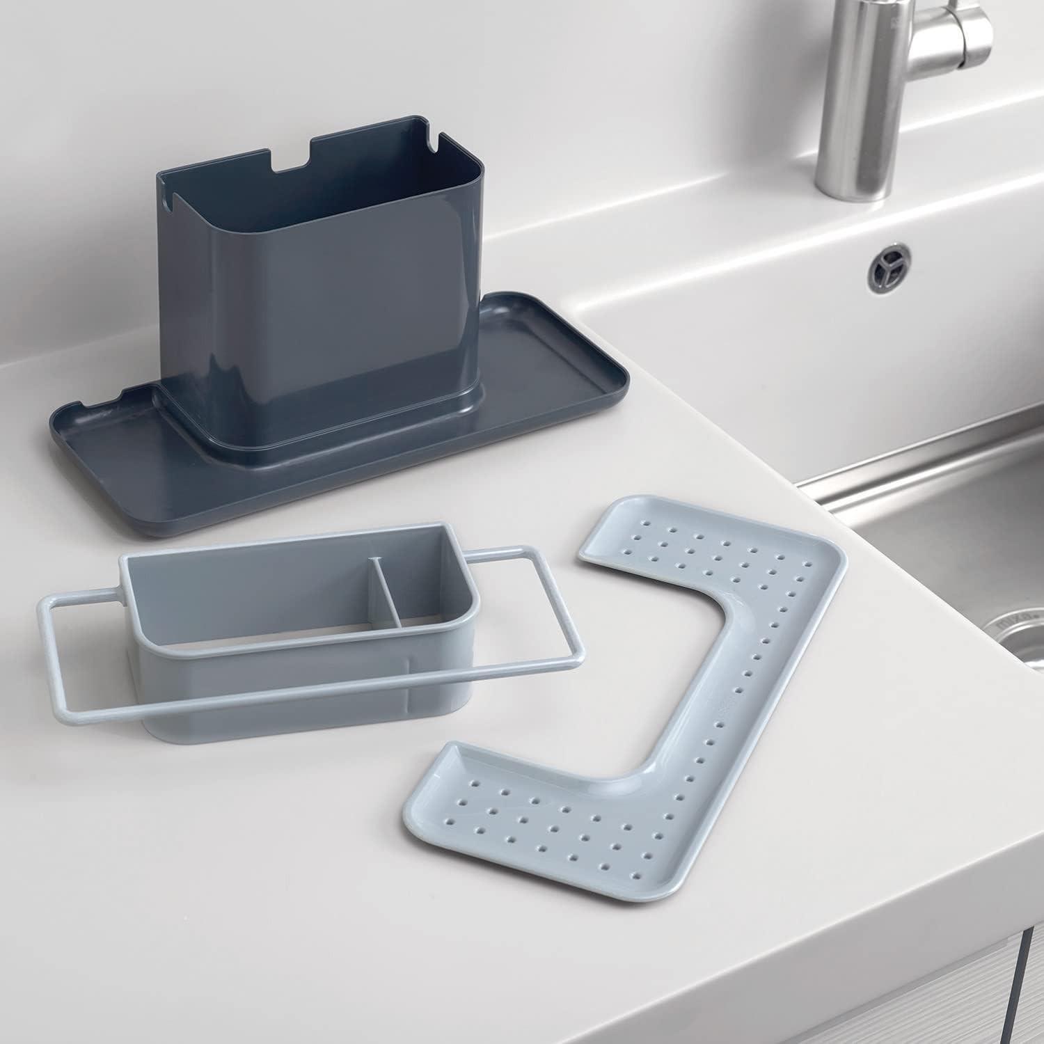 Grey kitchen sink caddy organizer with compact inserts and draining base near faucet