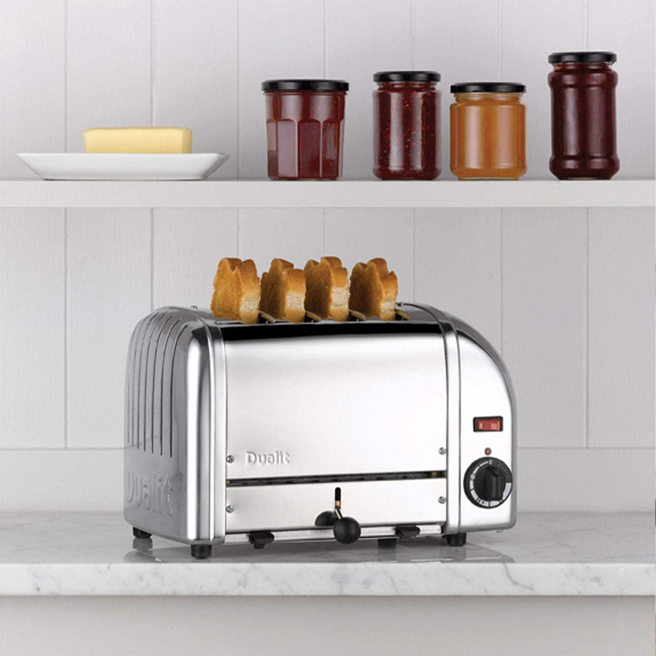 Stainless steel 4-slice toaster on kitchen countertop with visible lever and control dial