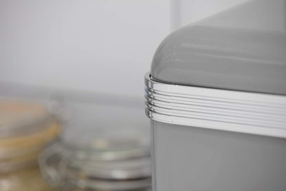Close-up of grey canister lid edge with silver ribbed trim and metal knob