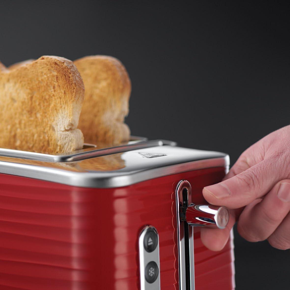 Red 2-slice toaster with lever pressed by hand and bread in the slot