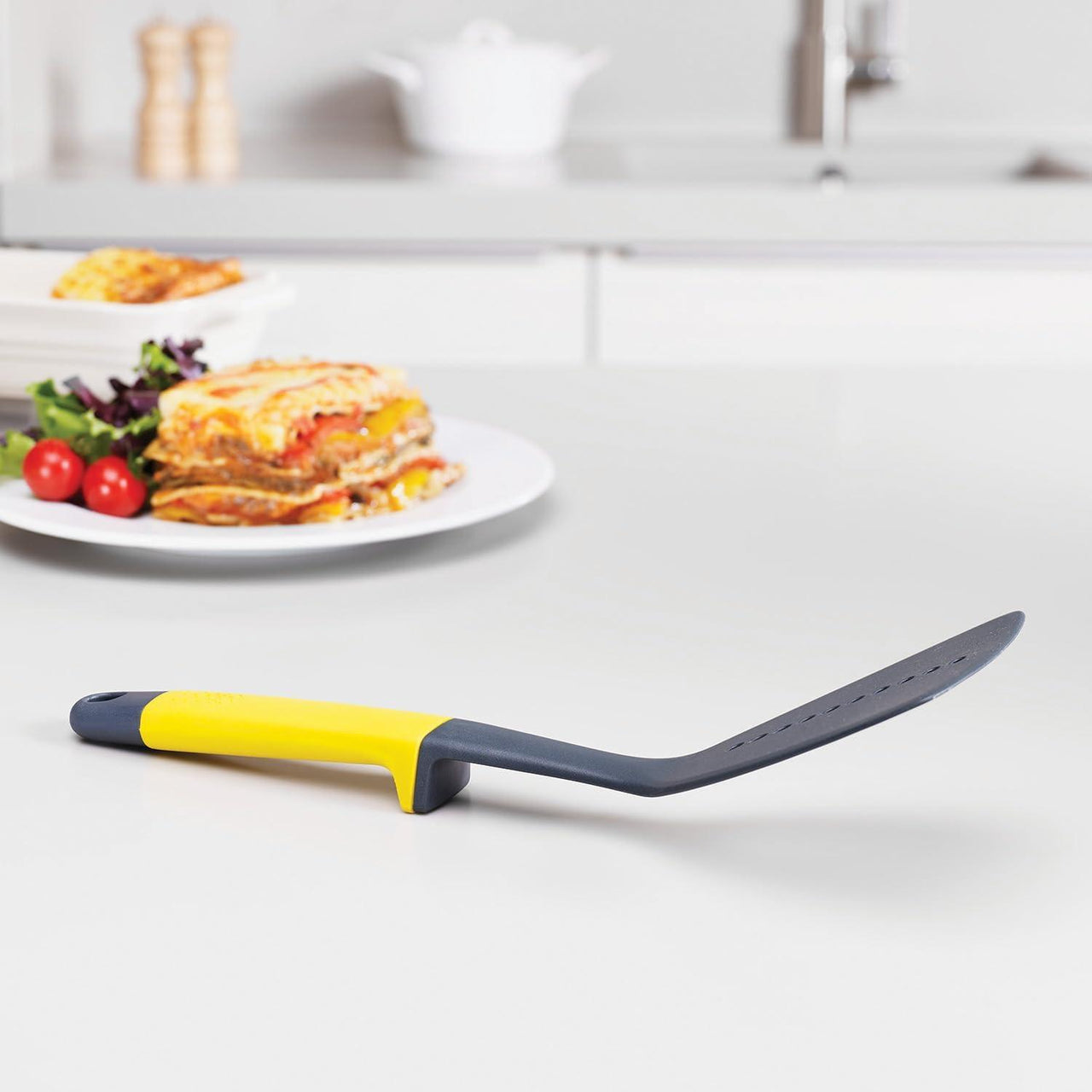 Kitchen slotted spatula with yellow handle and dark gray head, utensil set piece