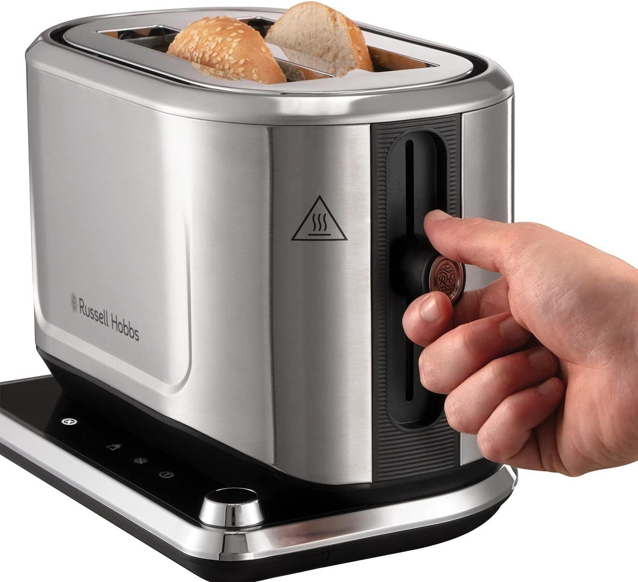 Stainless steel 2-slice toaster with bread in slots and hand using the lever