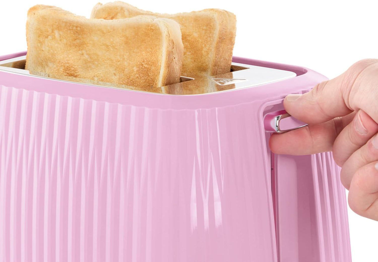 Pink toaster with bread in the chamber and a hand pressing the lever.