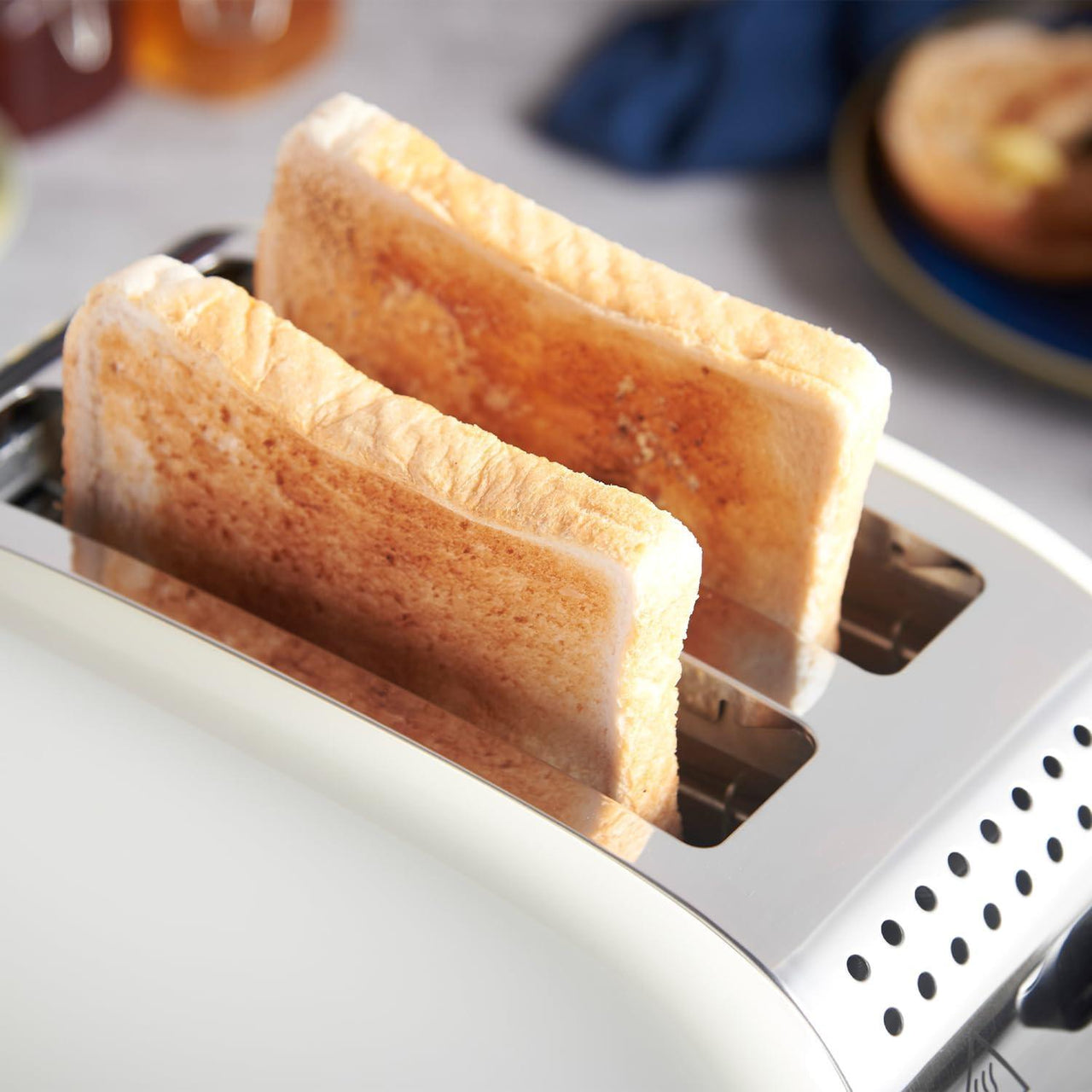 Jasmine cream 2-slice toaster with two toast slices in the heating slots.