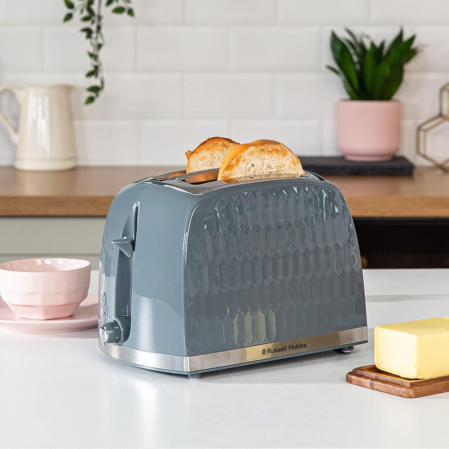 Grey 2-slice honeycomb toaster on countertop with toast ready to serve