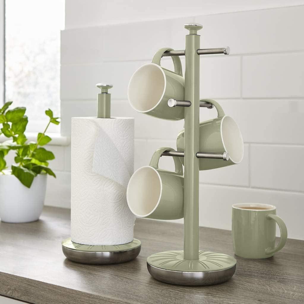 Green mug tree stand with four hooks holding three mugs and a paper towel roll