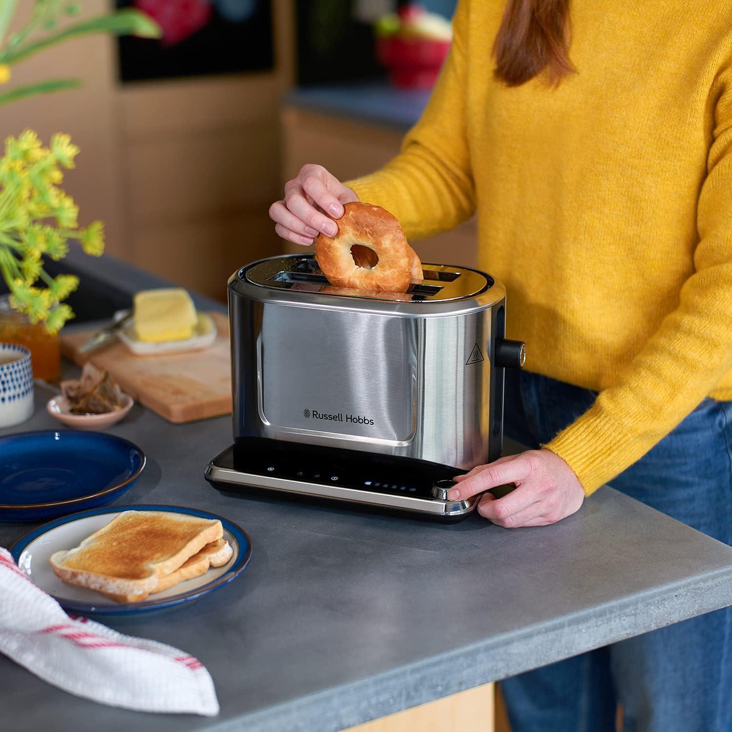 Stainless steel 2-slice toaster on countertop with bread rising in the slots