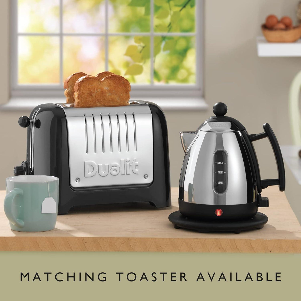 Stainless steel mini jug kettle with black handle and base on countertop, water level panel visible