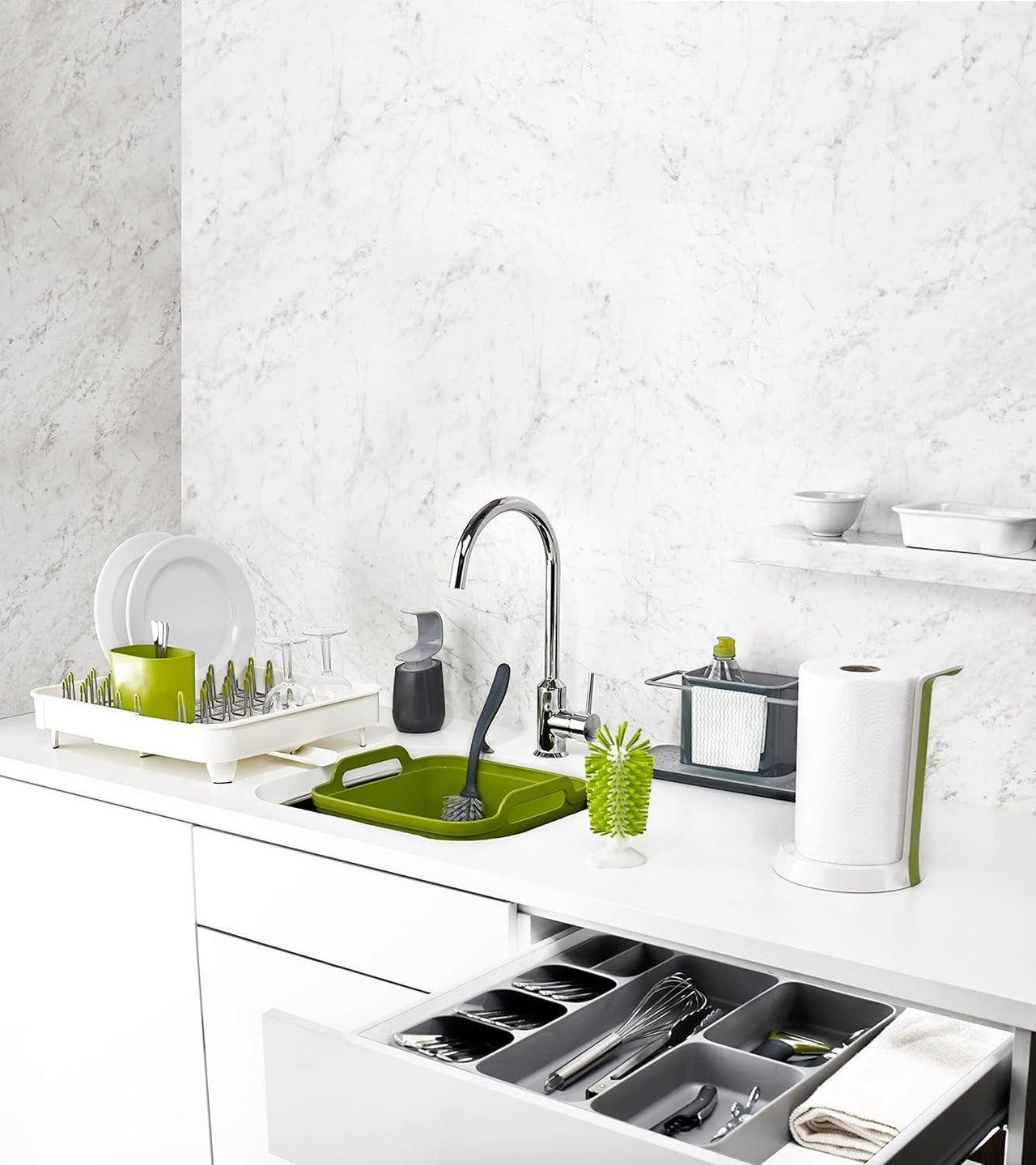 Grey kitchen sink caddy organizer on countertop with cleaning bottles and brush