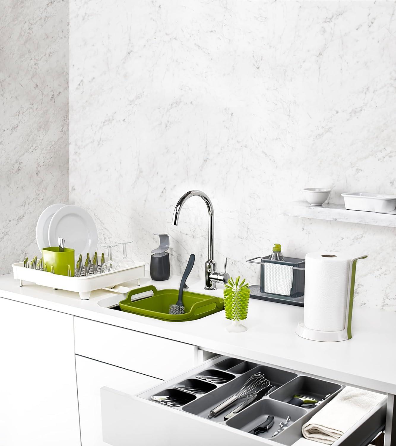 Grey kitchen sink caddy organizer on countertop with cleaning bottles and brush