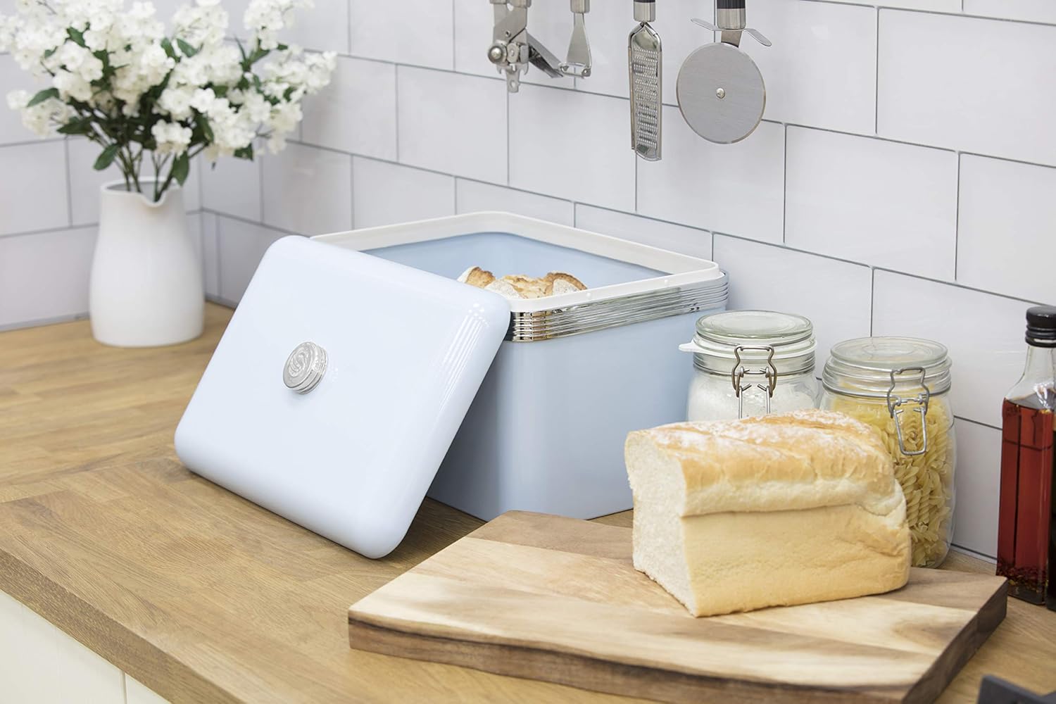 Blue bread bin with matching canisters on a wooden kitchen counter
