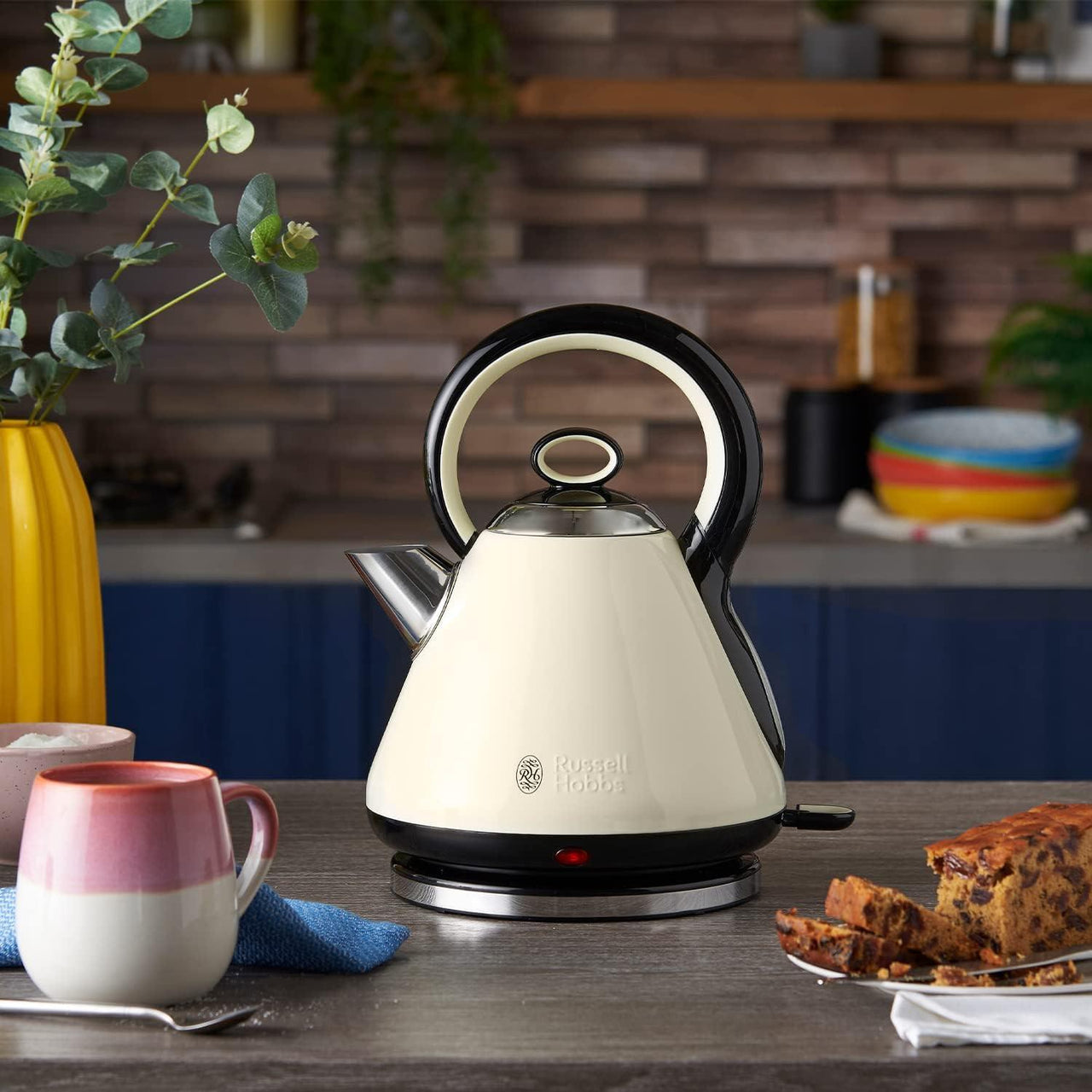 Cream electric kettle on countertop with black base, spout, and side handle