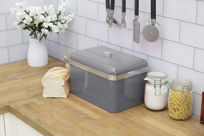 Grey retro bread bin with silver ribbed trim beside kitchen jars and bread pieces