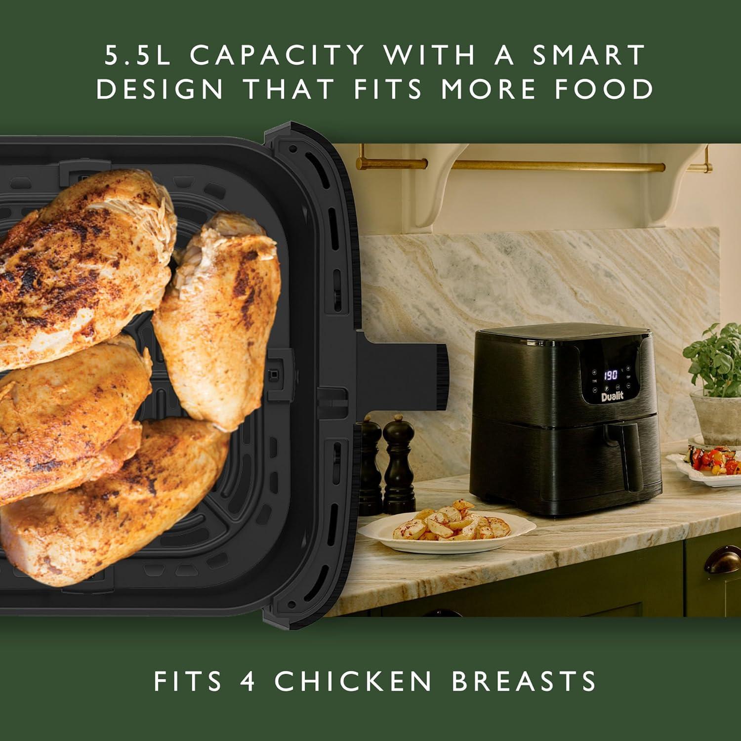 Air fryer basket with roasted chicken inside and black Dualit unit nearby.