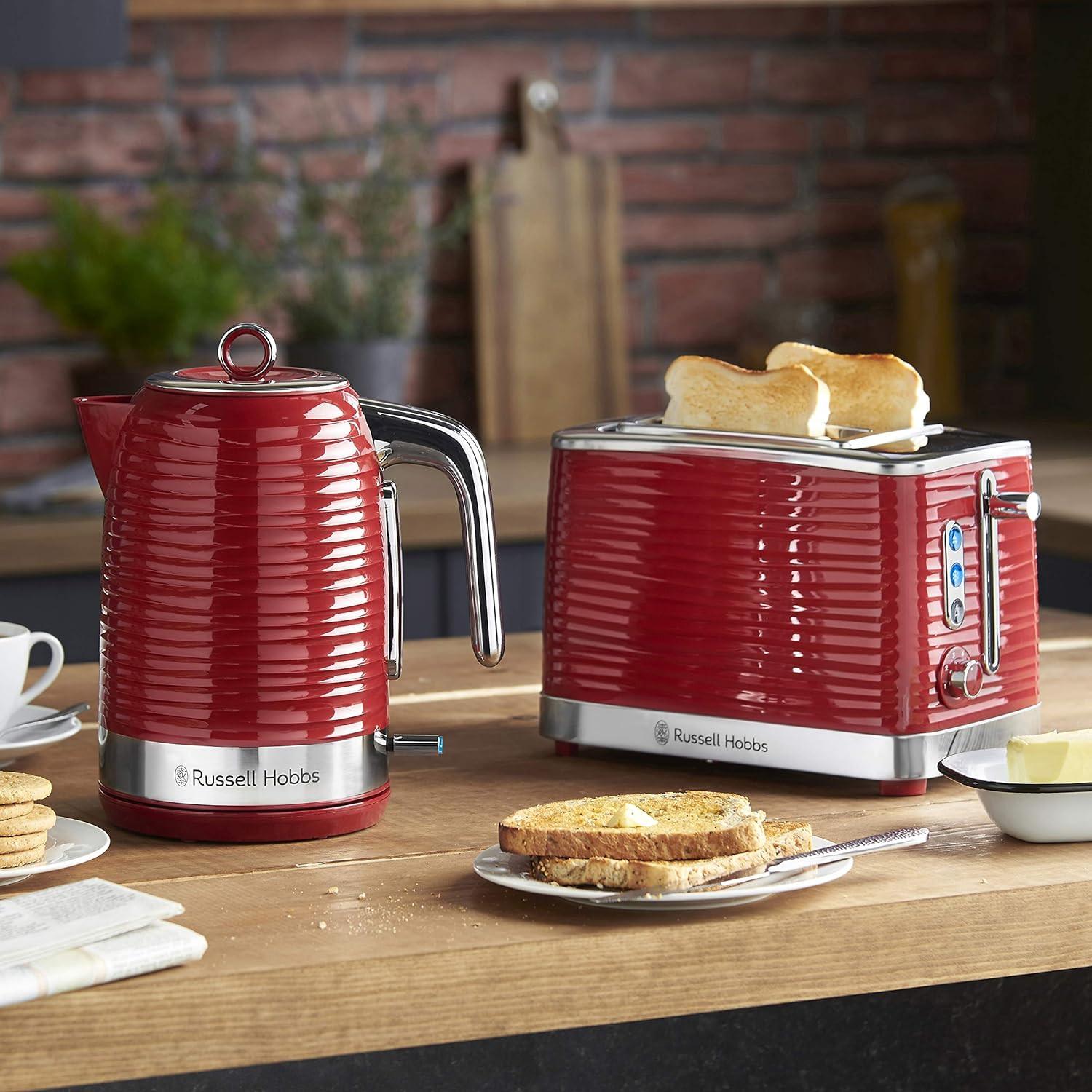 Red 2-slice toaster with bread in slots and side lever, on countertop