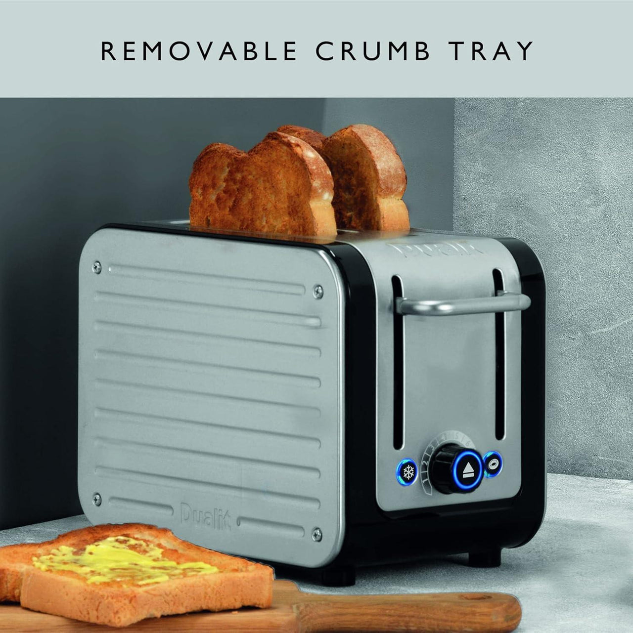 Black and silver toaster with crumb tray and lever area, shown with sliced bread.