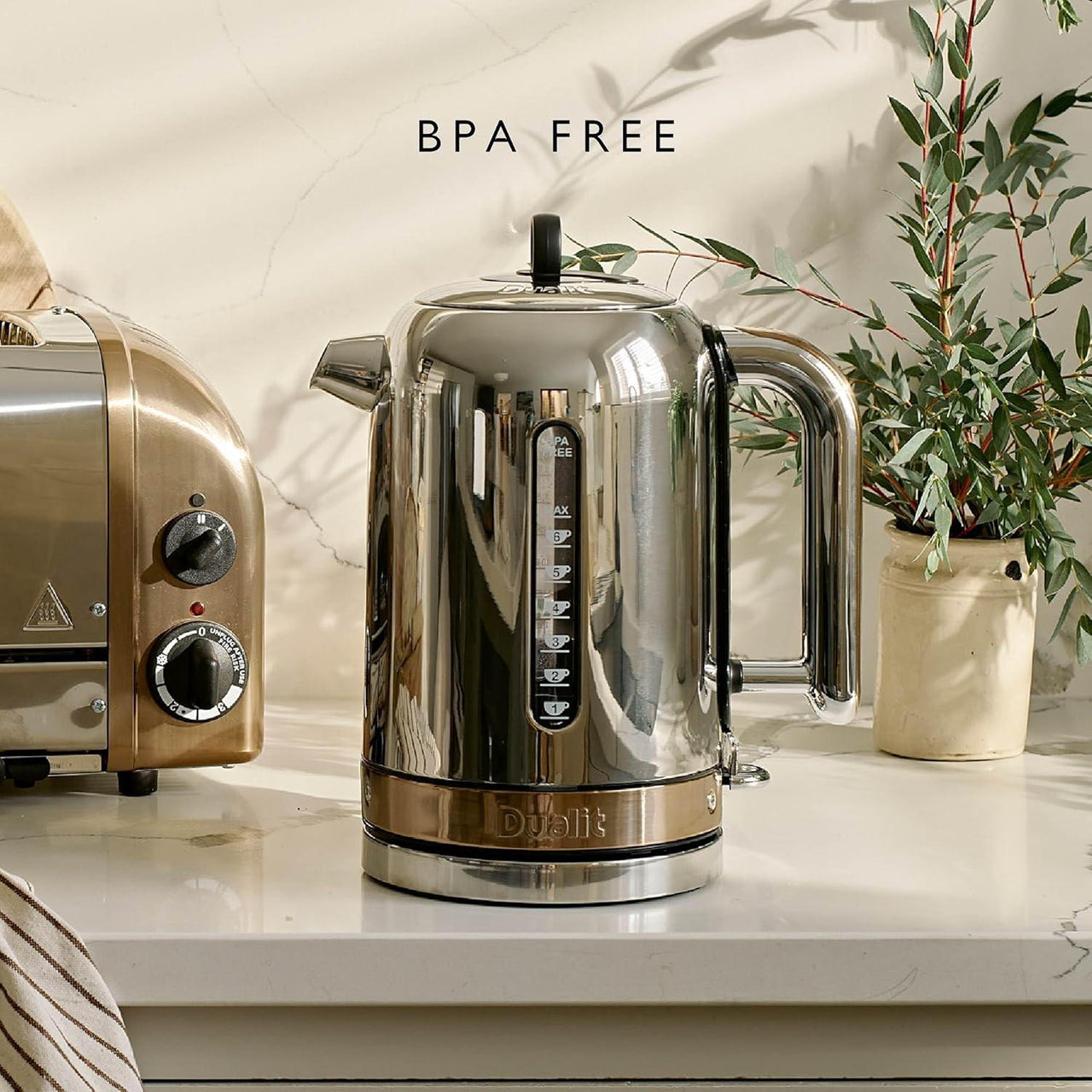 Dualit stainless steel jug kettle with copper trim and black control panel on countertop