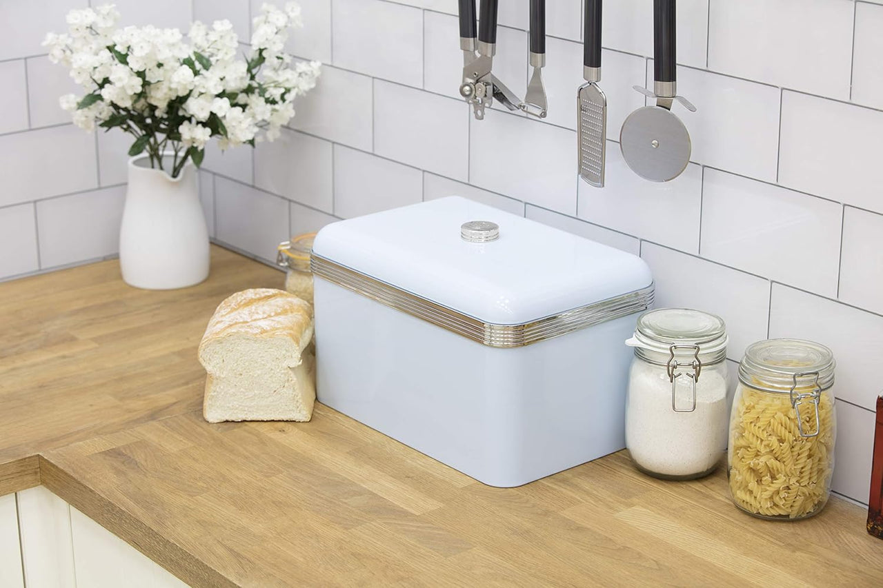 Blue retro bread bin with lid and three glass-style storage canisters; bread pieces nearby