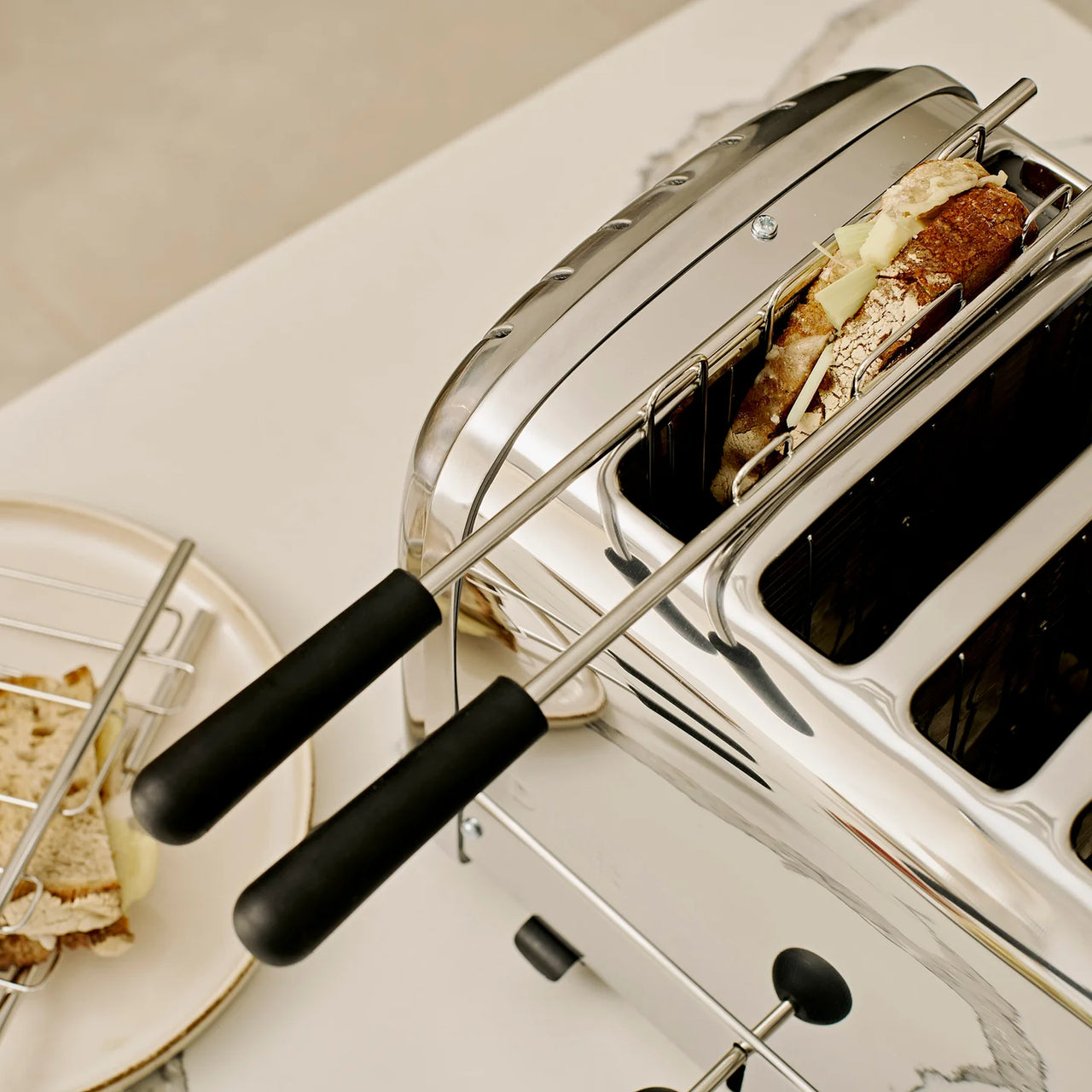 Stainless steel toaster with open rack and bread slices
