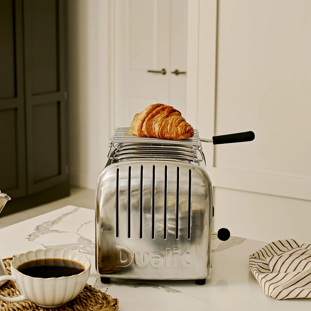 Stainless steel toaster with golden pastries rising from the slots