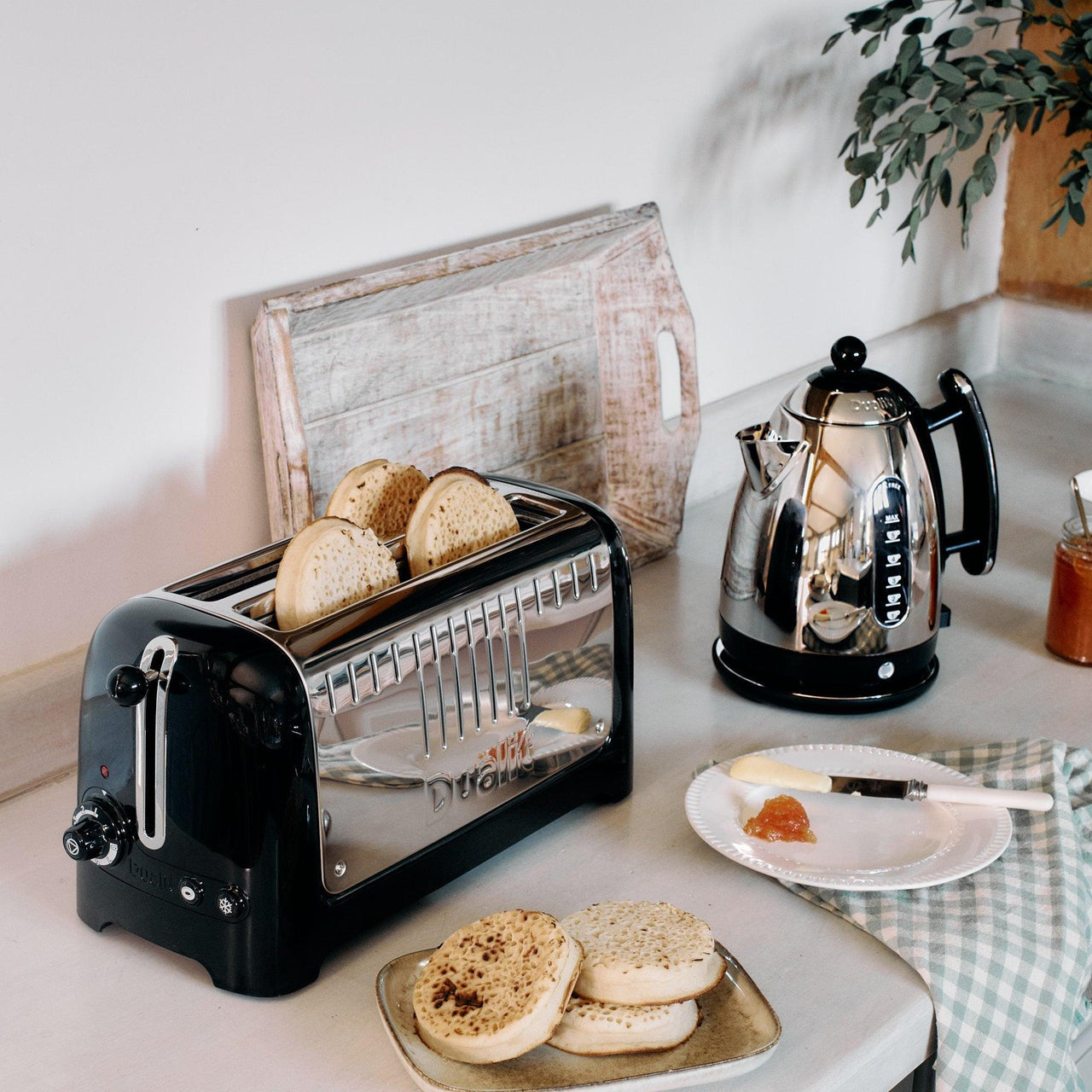 Black long-slot toaster on kitchen counter near kettle and sliced bread