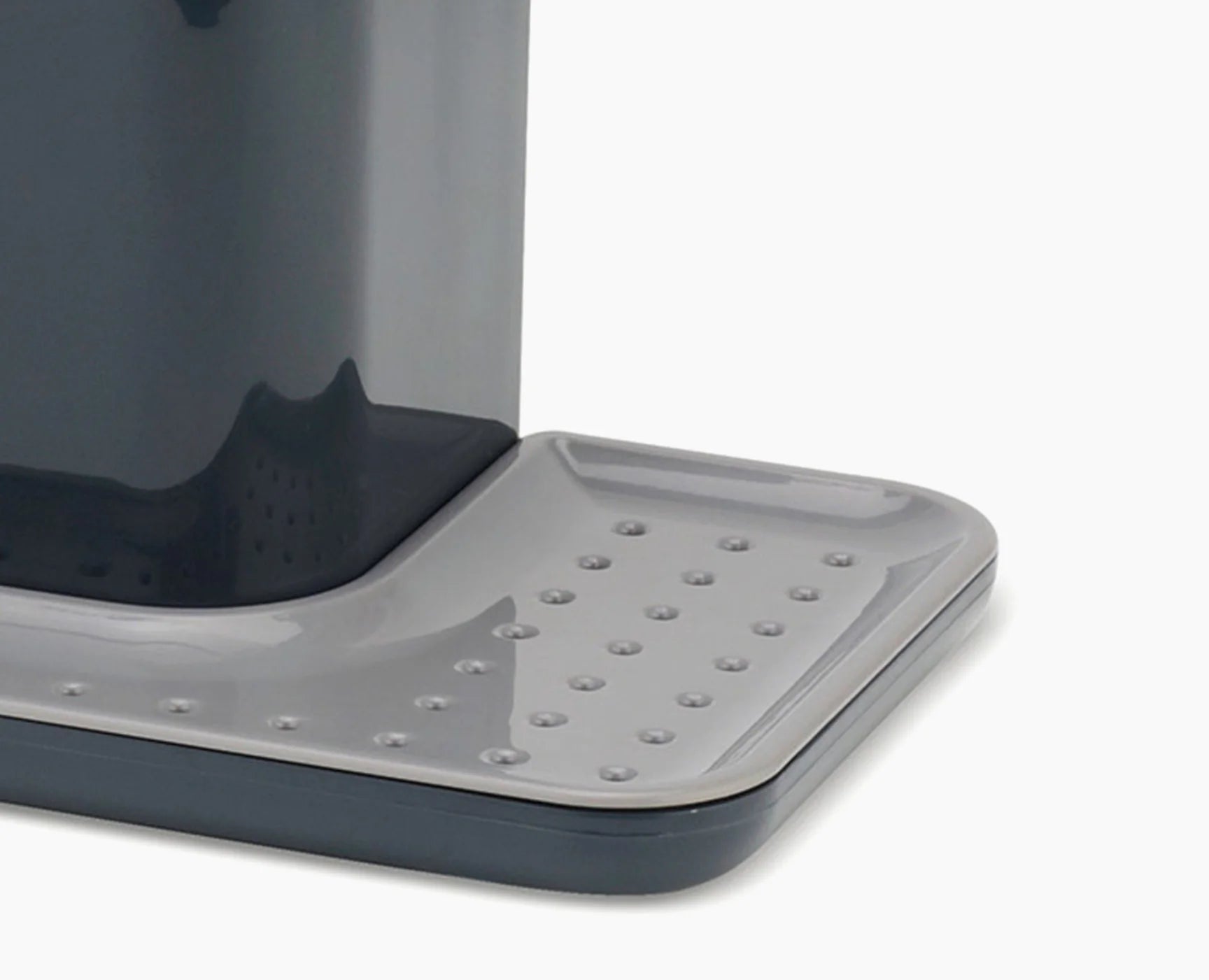 Grey kitchen sink caddy base with raised draining holes and textured surface