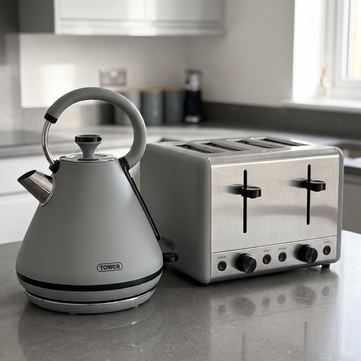 A silver De'Longhi electric kettle and a four-slot toaster sitting on a gray kitchen countertop in a modern kitchen setting.